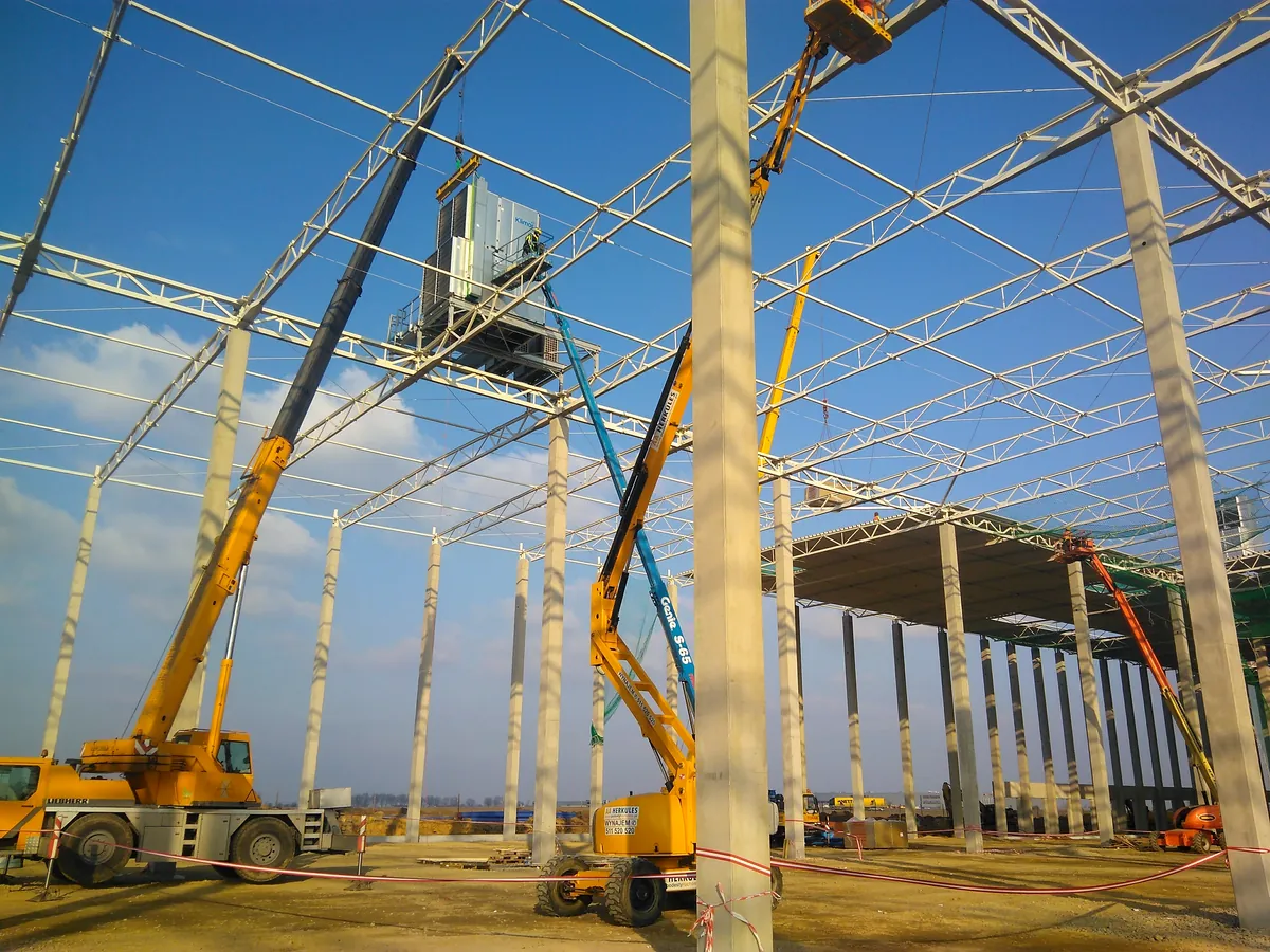 Air handling unit lifted by crane during installation on an industrial site